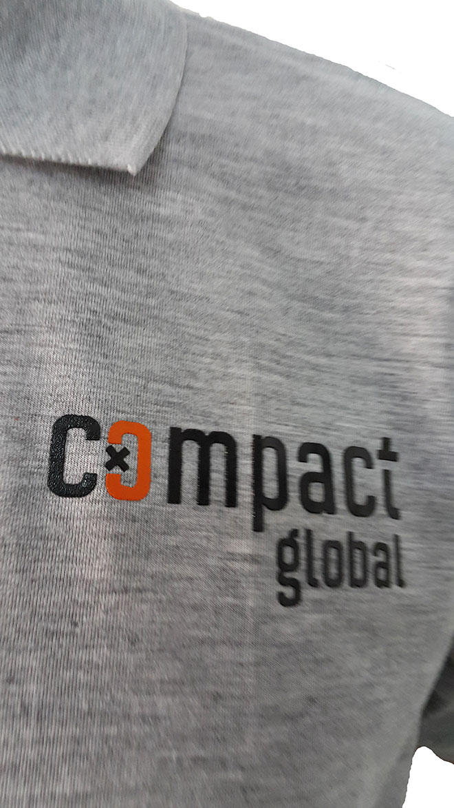 Chi tiết in kéo lụa lên áo Compact Global cổ trụ.